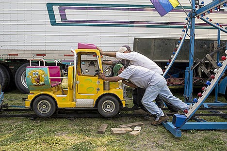 &lt;p&gt;Ronald Hebewah, front, and Cliff Heystad push a Spongebob Squarepants-themed roller coaster car while building the track for it Tuesday at the Kootenai County Fairgrounds.&lt;/p&gt;