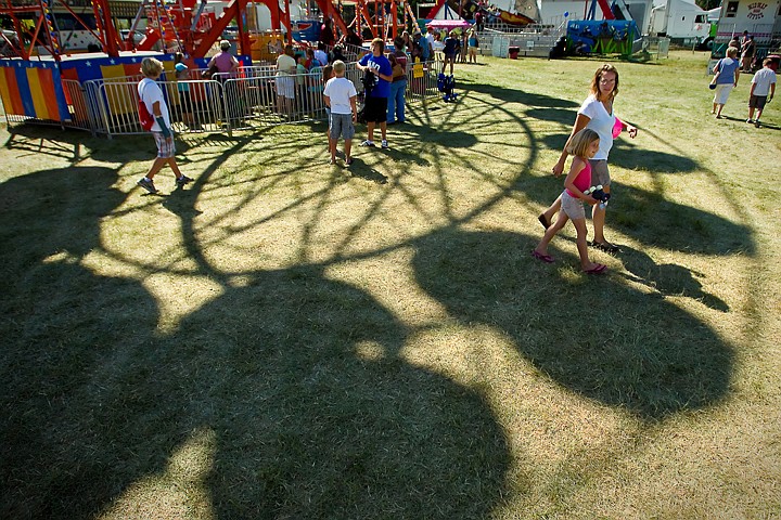 &lt;p&gt;Jonni Horton and her daughter Cooper Horton, 6, walk beneath the ferris wheel on the midway of the North Idaho Fair on opening day Wednesday.&lt;/p&gt;