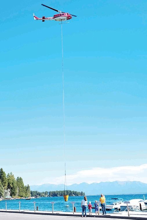 <p>A helicopter scoops up water Monday morning from Flathead Lake near Lakeside to battle the Stoner Creek Fire west of Lakeside. (Patrick Cote/Daily Inter Lake)</p>