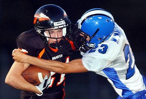 Flathead High School's Jareth Wilson tries to get past Coeur d'Alene High School's Weldon Warren during the second half of Flathead's 21-14 loss Friday night in Kalispell. It was the season opener for both schools. Chris Jordan/Daily Inter Lake