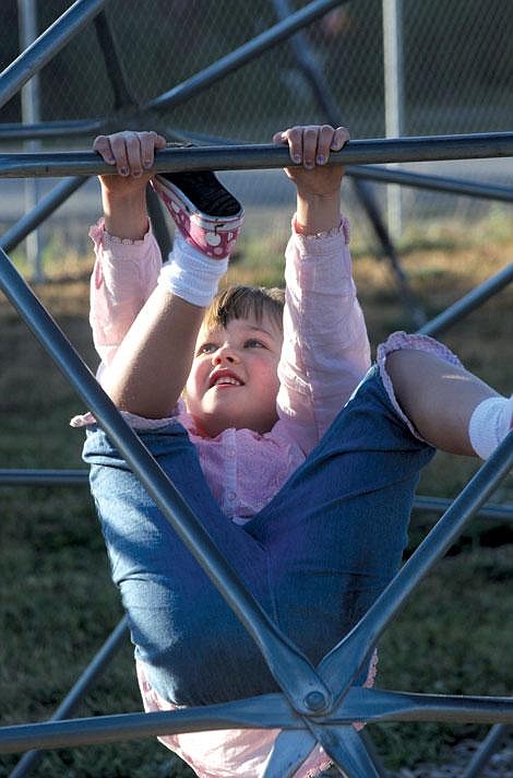 Jennifer McBride/Valley Press Kendra Brown, 5, shimmies up bars in the playground before her first day of school at Wildhorse.