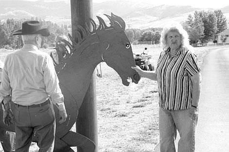 Jamie Doran/Valley Press Don Grazier and Sonya White stand next to one of the horse sculptures Grazier made.