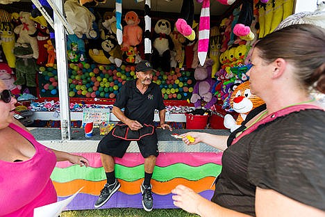 &lt;p&gt;&#160;TW Hamm describes the rules of the balloon game at his fair booth.&lt;/p&gt;