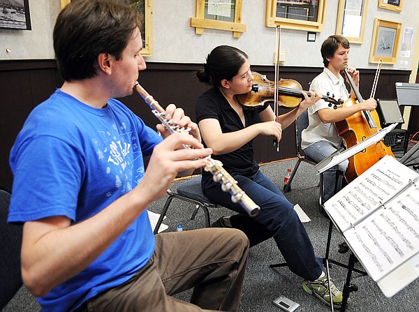 Visiting Juilliard students Shawn Wyckoff, flute, left to right, Maria Millar, violin, and Adrian Daurov, cello, play a few songs for music students gathered at the Discovery Center on Thursday in Columbia Falls.