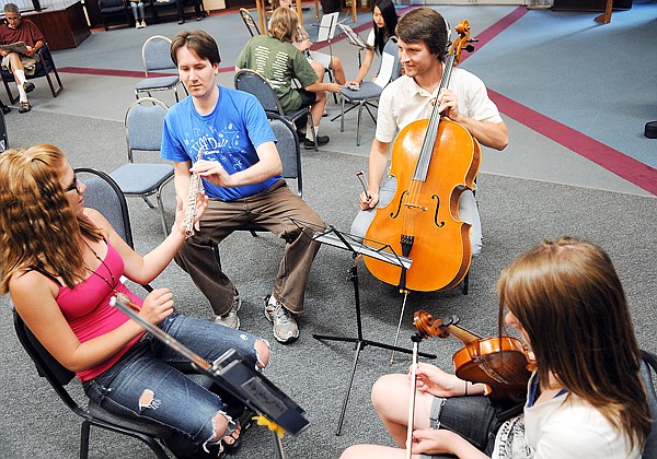 Shawn Wyckoff, left center and Adrian Daurov, right center, work with Taylir Fairbank, 14, of Columbia Falls, far left, and Alexis Larson, 13 of Kalispell, as students break into small groups to receive personal attention from the visiting Juilliard students.