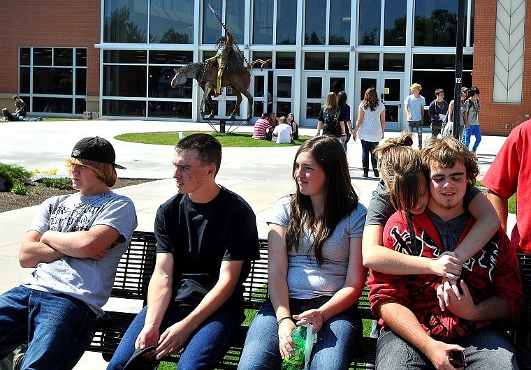 Sophomore Eli Kupka, 15, gets a hug from freshman Kinzie Johnson, 15, while the two sit outside Flathead High School during their lunch hour.