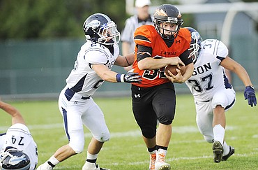 <p>Flathead's Payton Boyce attempts to run through two Great Falls' defenders during the second quarter at Legends Stadium Friday. (Aaric Bryan/Daily Inter Lake)</p>