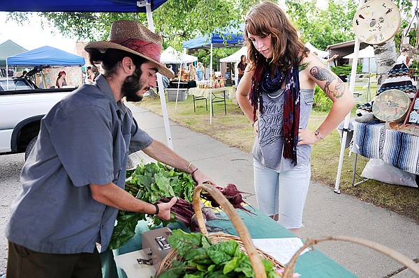 Joseph Fetherolf and Holly Rog set up their stall at the Columbia Falls Farmers Market on Thursday, July 29.