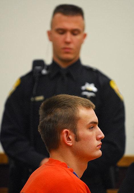 Shane Nickerson listens to the felony abuse charges against him during his arraignment in Flathead County District Court on Thursday morning. He is accused of assaulting a 9-month-old boy. Flathead County Detention Officer J. Cammack stands guard over Nickerson. Garrett Cheen/Daily Inter Lake