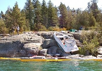 The 22-foot boat that carried Rep. Denny Rehberg, R-Mont., state Sen. Greg Barkus, R-Kalispell, and three other people rests on the rocks just south of the Wayfarer State Park pier on Friday. The boat crashed after 10 p.m. Thursday, injuring all five people aboard. Jim Mann/Daily Inter Lake