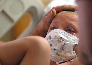 KILEY TRIES to hold back tears as she has blood drawn out of the mediport in her chest in order to check her blood cell counts before treatment begins at Kalispell Regional Medical Center's Outpatient Infusion Wednesday morning. Allison Money/Daily Inter Lake