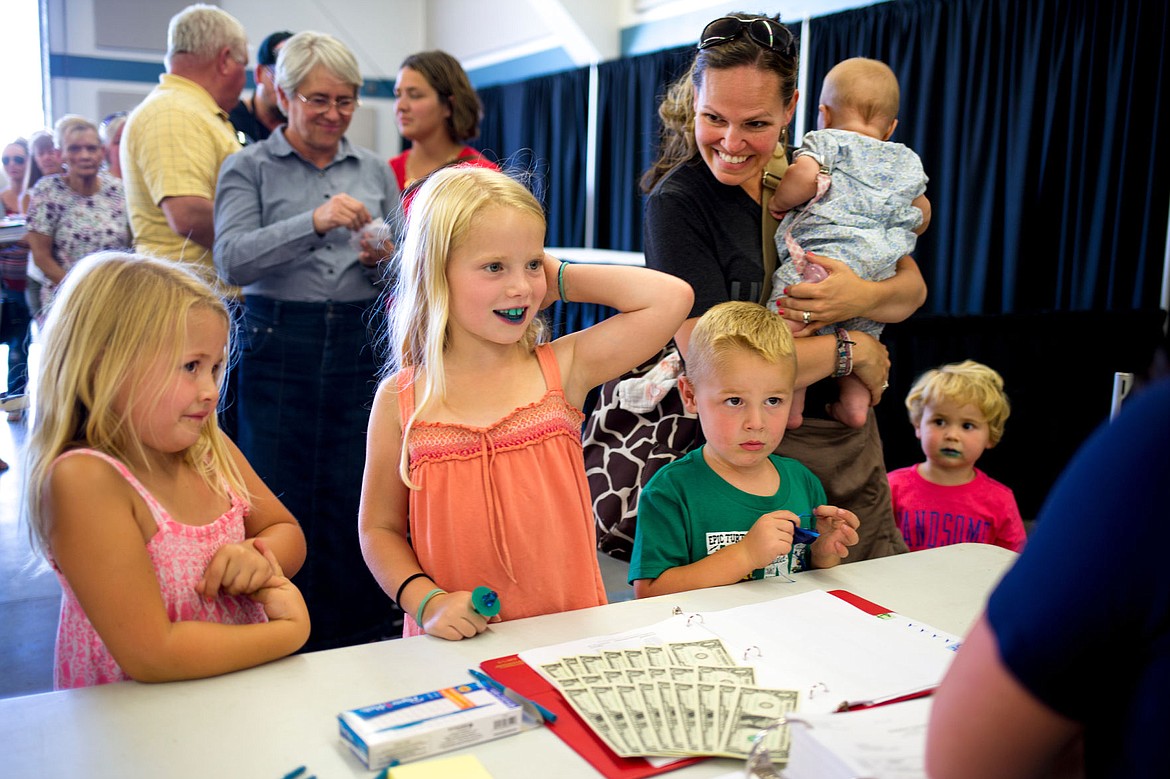 &lt;p&gt;Her mouth blue from a candy ring, Addison Kunze, 7, smiles as she receives a cash prize on Monday for her involvement in the North Idaho State Fair's fine arts exhibits. Addison's siblings Ella, left, and Lyle, right, submitted art work to the fair as well.&lt;/p&gt;