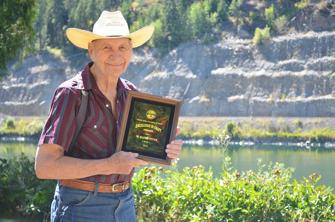 <p>Glenn Titus, 86, with his Excellence in Craft Award at his home near Troy on the Kootenai River. The Outdoors Writing Association of America honored Titus with the award earlier this month. (Seaborn Larson/The Western News)</p>