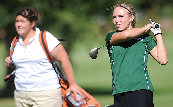 Shelby Ballard of Glacier, right, and Andrea Battello of Flathead watch as Ballard hits her ball onto the green on hole one during the Flatfish Invite on Monday at the Whitefish Lake Golf Club.