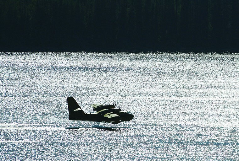 <p>A “Super Scooper” plane flies low over the south end of Hungry Horse Reservoir Thursday as part of the firefighting effort on the Dart Creek Fire in the Bob Marshall Wilderness. The Canadair CL-215 planes skim over the surface of the reservoir, pick up a load of water through special vents, then fly to the fire.</p>