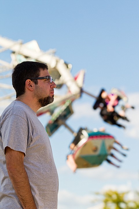 &lt;p&gt;SHAWN GUST/Press David Pearl, of Coeur d'Alene, watches his children on a ride while the Star Trooper spins in the background.&lt;/p&gt;