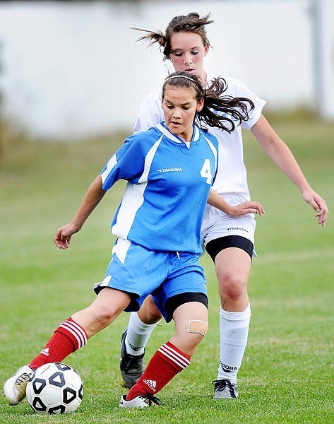 Bigfork junior Miranda Miller (4) works to keep the ball away from Columbia Falls junior Madison Sandefer (21) during Tuesday&#146;s match in Columbia Falls.