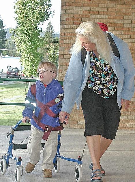 Georgina Woody, a student assistant for Libby Public Schools, walks alongside Luke Weber as the 7-year-old heads for Asa Wood Elementary on the first day of school. Born with Down Syndrome as well as three months premature, Luke has showed tremendous progress with his walking.