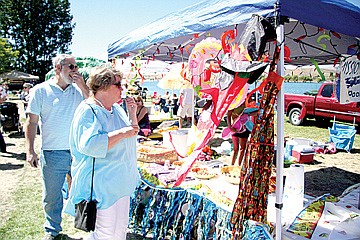 &lt;p&gt;Sue Toppen of Polson samples food at the Mission Valley Aquatics table at Saturday's Festival for Youth hosted by the Rotary Club.&lt;/p&gt;