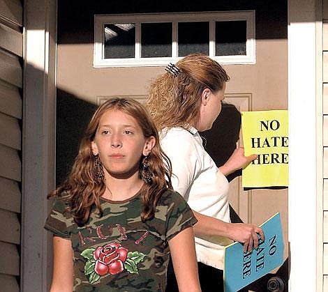 Jill Summers, right, and her daughter Brianna Murillo leave fliers in the doors of their neighbors Thursday night. Residents of the south Kalispell area are concerned about a family of white nationalists that recently moved into the neighborhood. A group of about 20 adults and children distributed the fliers. Karen Nichols/Daily Inter Lake