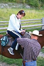 Cathy Bronsdon saddles up on her horse, Sam, with the help of guide Matt Cheff.