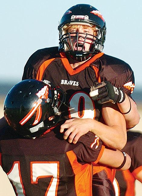 Flathead QB Brock Osweiler hugs Reed Watkins after a touchdown reception at Legends Stadium Friday night. The two hooked up for three scores in a 43-20 victory over Billings Skyview. It was the season opener for the Braves. Chris Jordan/Daily Inter Lake