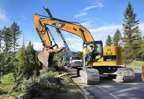 A construction crew works on the roadside along Willow Glen Drive on Monday in Kalispell. The area is the future home of walking/bike trail.