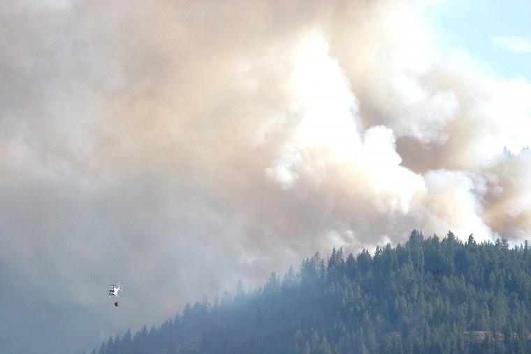 &lt;p&gt;The helicopter flies back towards the river after dumping water on the blaze Sunday afternoon.&lt;/p&gt;