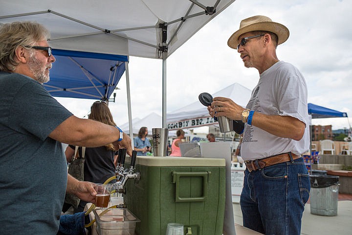 &lt;p&gt;JAKE PARRISH/Press&lt;/p&gt;&lt;p&gt;Paradise Creek Brewery owner Tom Handy pours Mark Vehr of Coeur d'Alene a cup of Huckleberry Pucker on Saturday at the North Idaho Trail Foundation's Ales for Trails microbrew festival in McEuen Park. The festival raises money to fund the Centennial Trail, and offers live music and beer tasting.&lt;/p&gt;