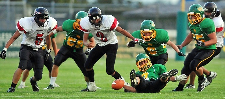 Players from both sides eye a fumbled football by the Indians, which the Bulldogs were able to recover.