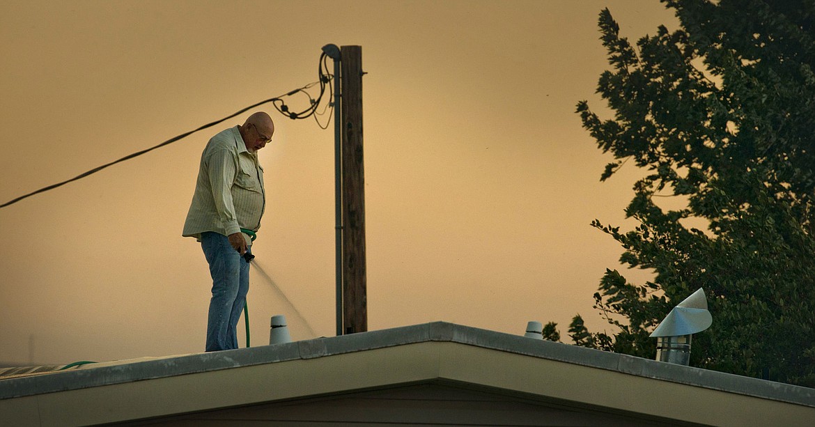 &lt;p&gt;In this Sunday, Aug. 21, 2016, photo, homeowner Dale Nelson wets the roof of his home north of Walla Walla, Wash., as wildfire closes in. Firefighters from several districts were able to stop the blaze at Hwy 125, about a quarter mile shy of the Nelson home. The fire, whose cause in under investigation, burned several thousand acres in very high winds. (Greg Lehman/Walla Walla Union-Bulletin via AP)&lt;/p&gt;