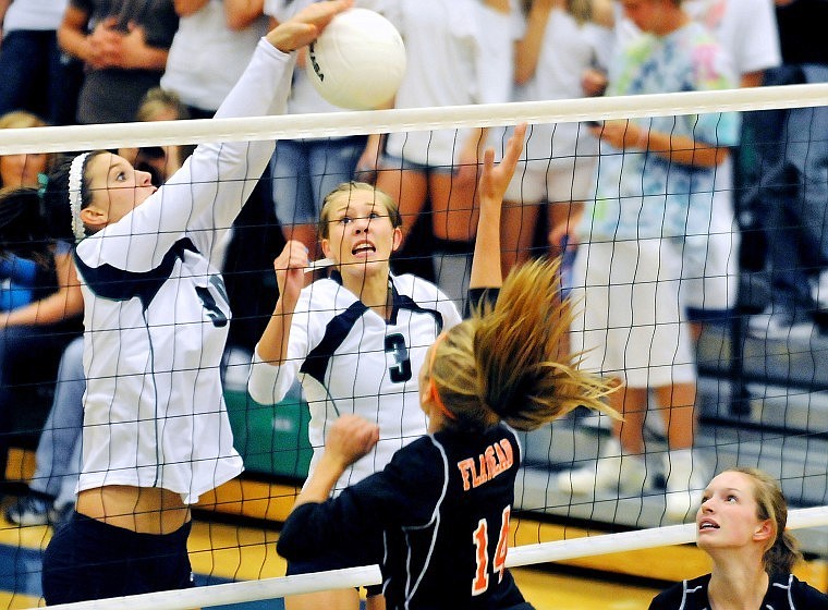 Glacier's Cassidy Hashley blocks a hit at the net by Flathead's Timi Severson (14) while Lexy Boschee (3) and Emily Russell look on during Thursday evening's crosstown match at Glacier High.