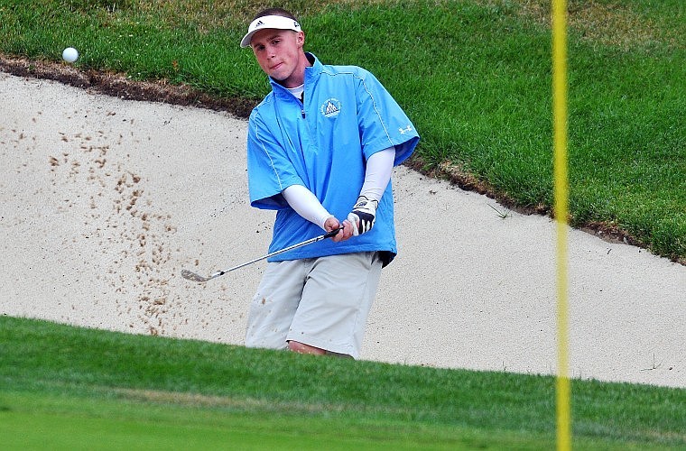 PARKER JOHNSON of Columbia Falls chips out of a sand trap during the Flatfish Invitational at Whitefish Lake Golf Club Tuesday morning.