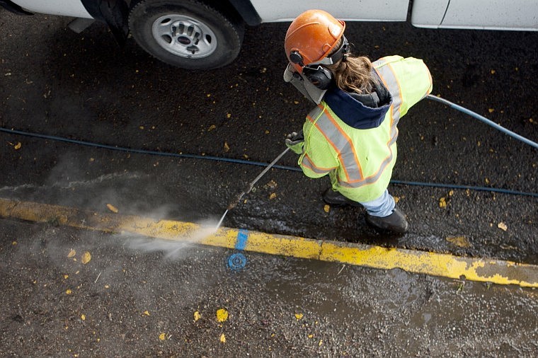 &lt;p&gt;Angela Daedario uses a pressure washer to clear debris from
cracks in the curb and street Wednesday morning.&lt;/p&gt;