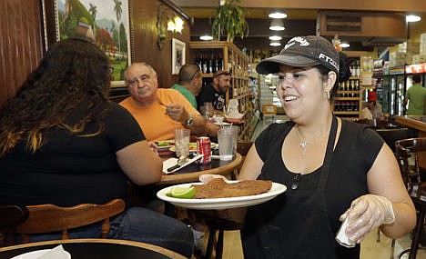 &lt;p&gt;Judith Castro serves a lunch order at a local grocery store in the Little Havana area of Miami on June 12.&lt;/p&gt;