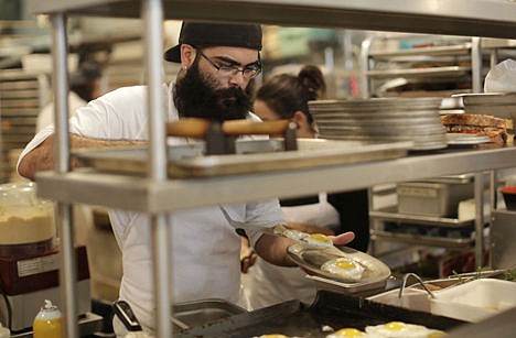 &lt;p&gt;Sous chef Johnny Bacon places fried eggs on a plate while filling an order at Zak the Baker, in Miami on June 5.&#160;&lt;/p&gt;