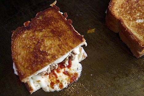 &lt;p&gt;The cheese from a sandwich bubbles up as it melts onto the grill.&lt;/p&gt;