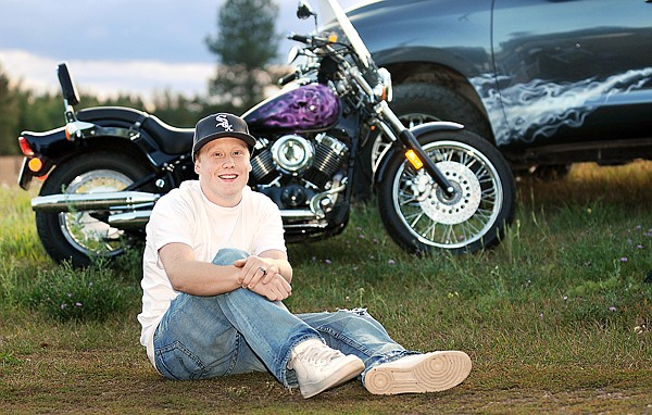 Ely Yerian, 23, of Columbia Falls, with two of the vehicles he has painted on Monday at his home in Columbia Falls.