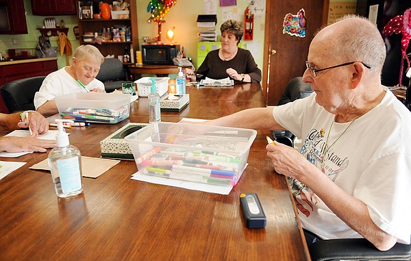 Duncan Wellington of Kalispell, right, Randy Bartcher of Kalispell, left and senior staff member Gail Funke work on craft projects Aug. 2 at Flathead Industries.