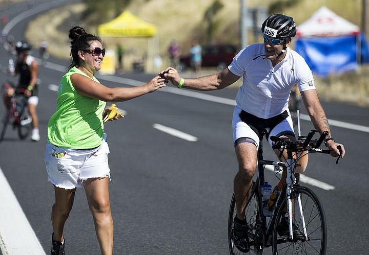 &lt;p&gt;Plummer resident Jesse Hodgson hands a banana to Douglas Reeves, of McMinnville, OR., as he bikes south on Highway 95, Saturday, during Ironman Coeur d'Alene.&lt;/p&gt;