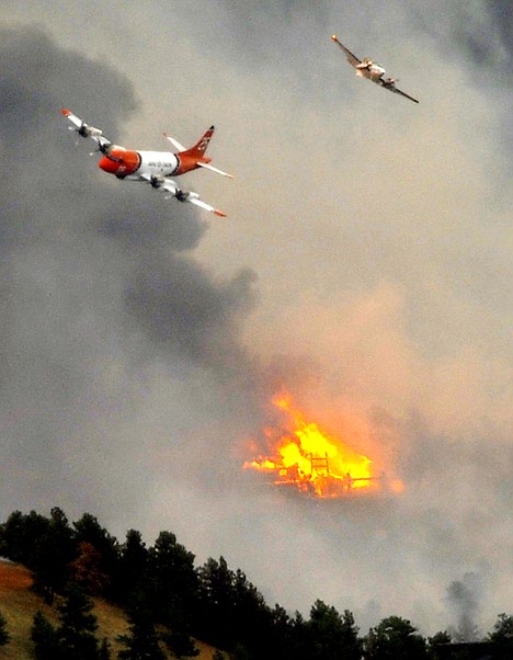 &lt;p&gt;A spotter plane and large slurry bomber pass over a burning home in Bolder, Colo., on Tuesday.&lt;/p&gt;