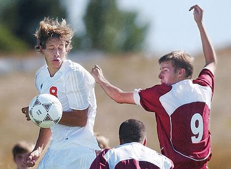 Flathead High School senior Jeremy DeHerrera, left, and Helena High senior Kevin Harlen battle for a header during Flathead's 4-2 victory Thursday afternoon in Kalispell. Chris Jordan/Daily Inter Lake