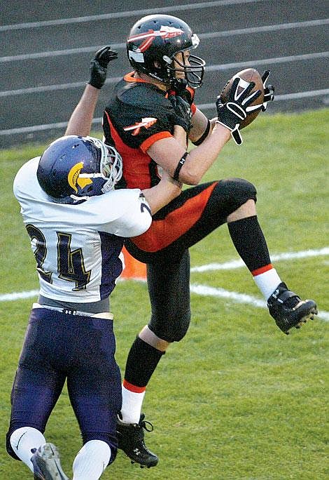 Flathead&#146;s Brandon Schmaus goes up for a pass from quarterback Brock Osweiler in the end zone while a Missoula Spartan tries to defend on the play during the second quarter of Friday night&#146;s game at Legends Stadium in Kalispell. Schmaus&#146; touchdown catch put the Braves up 20-0 against the Spartans. Craig Moore/Daily Inter Lake