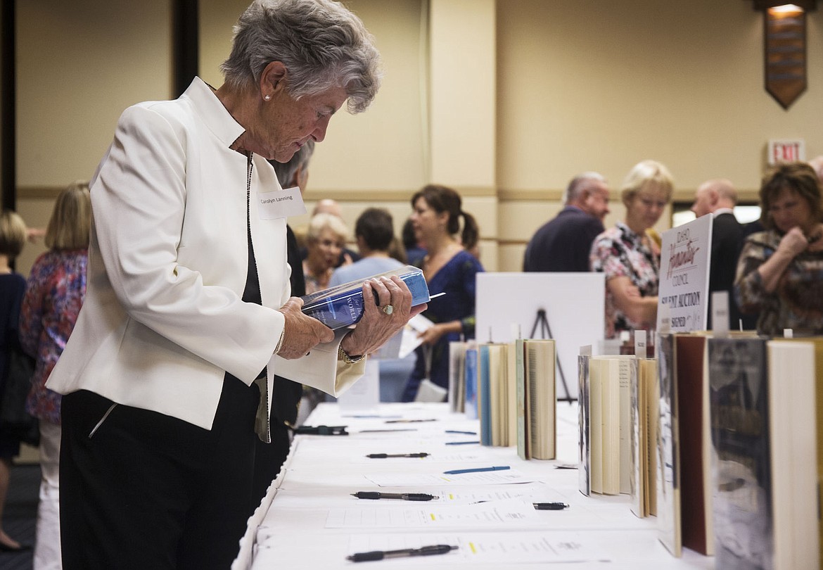 &lt;p&gt;Carolyn Lanning picks up the book, &quot;Wheels for the World,&quot; on Thursday at the Idaho Humanities Council silent auction.&lt;/p&gt;