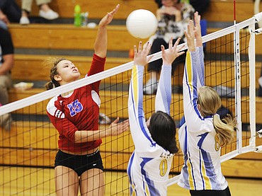 <p>Columbia Falls' Carla Nicosia blast the ball past two Libby defenders during the Wildkats straight-set win against the Loggers in Columbia Falls on Thursday. (Aaric Bryan/Daily Inter Lake)</p>
