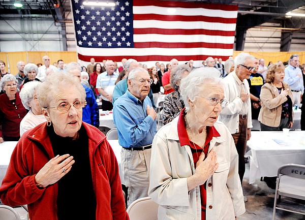 Carol Freeman of Kalispell and Carolyn Robinson of Evergreen and others take part in the sining of the National Anthem on Saturday at the Celebrate America! event in Kalispell.