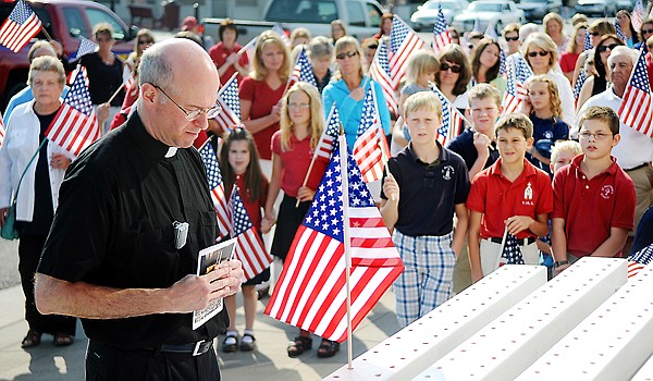 &lt;p&gt;Brenda Ahearn/Daily Inter Lake&lt;/p&gt;&lt;p&gt;The Rev. Rod Ermatinger of St. Matthew&#146;s Parish places the first
flag Friday morning at a 9/11 memorial outside the Kalispell Fire
Hall. The flag was placed in memory of New York Fire Department
Chaplain Mychal Judge, who died in the terrorist attack on the
World Trade Center. In the background, students, staff, and family
members carry 343 flags honoring the first responders who were
killed 10 years ago.&lt;/p&gt;