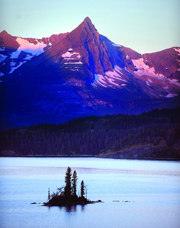 &lt;p&gt;Wild Goose Island is silhouetted against St. Mary Lake as
sunrise begins to brighten the peaks in the distance.&lt;/p&gt;