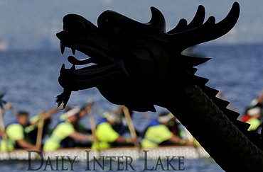 <p>Racers speed past a boat sitting ashore during the Montana Dragon Boat Festival at the Flathead Lake Lodge on Saturday. The third annual event featured 75 teams and is one of the 10 largest festivals in the nation. (Aaric Bryan/Daily Inter Lake)</p>