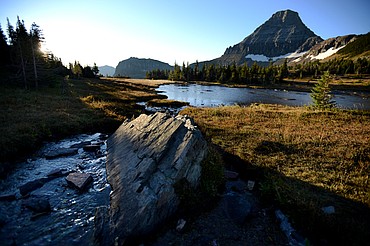 <p>The rising sun illuminates Reynolds Mountain above Logan Pass in Glacier National Park. The pass still is accessible to visitors driving from the east side on Going-to-the-Sun Road. West-side access is closed for road construction.</p>